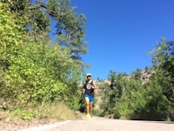 An active person jogging on a scenic trail surrounded by nature.