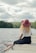 woman sitting on dock under cumulus clouds