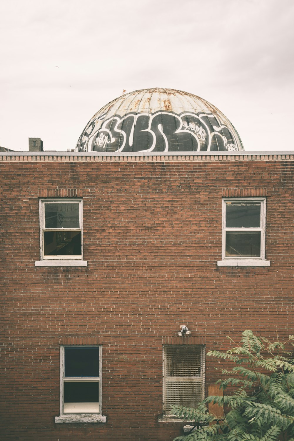 a brick building with graffiti on the side of it