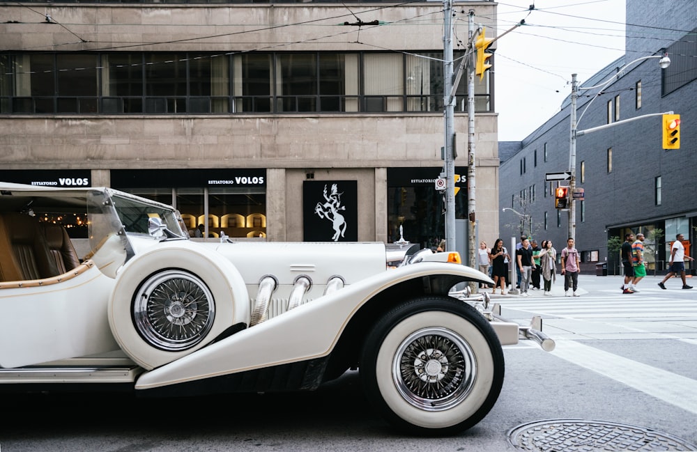 photo of classic white vehicle near pedestrian lane