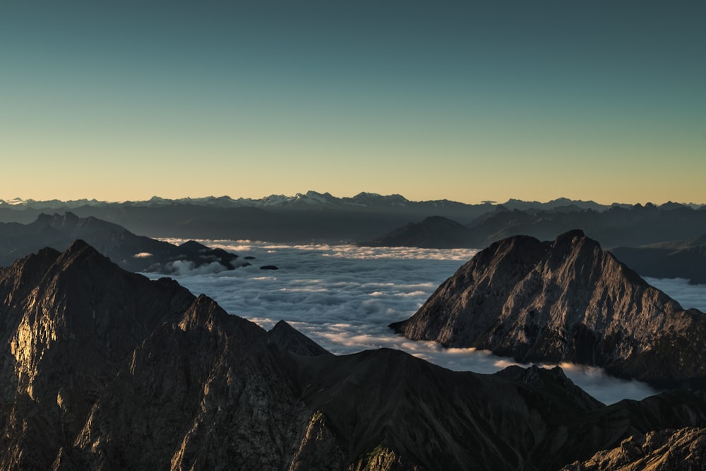 mountains surrounded with clouds in horizon