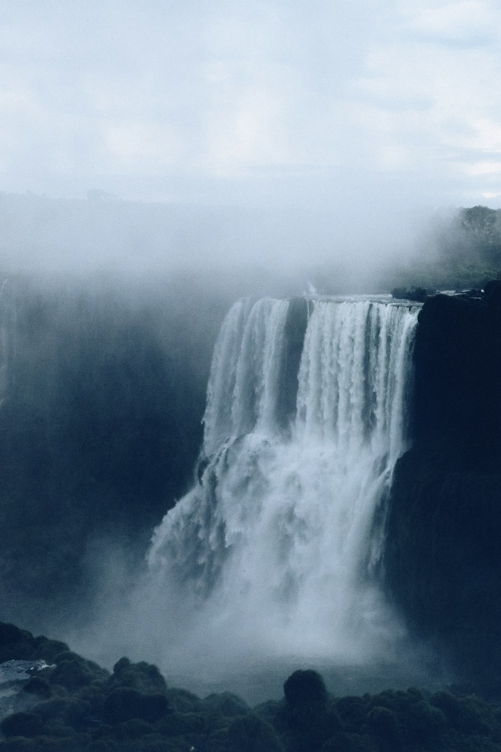 waterfalls in foggy weather during daytime