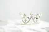 Elegant silver tiara reflecting soft cream silk textures with cinematic lighting.