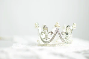 Close-up of a delicate bridal tiara sparkling with crystals against a soft white background