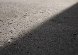Close-up of a smooth, laser screeded concrete surface reflecting sunlight.