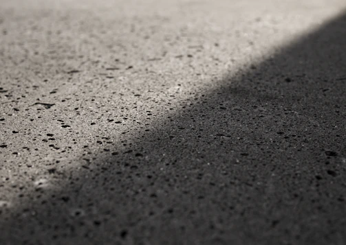 Close-up of a smooth, laser screeded concrete surface reflecting sunlight.