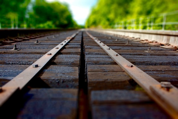 Close-up of wooden railroad sleepers stacked neatly beside train tracks