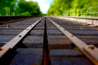 Close-up of wooden railroad sleepers stacked neatly beside train tracks