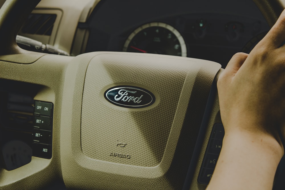 person holding Ford steering wheel