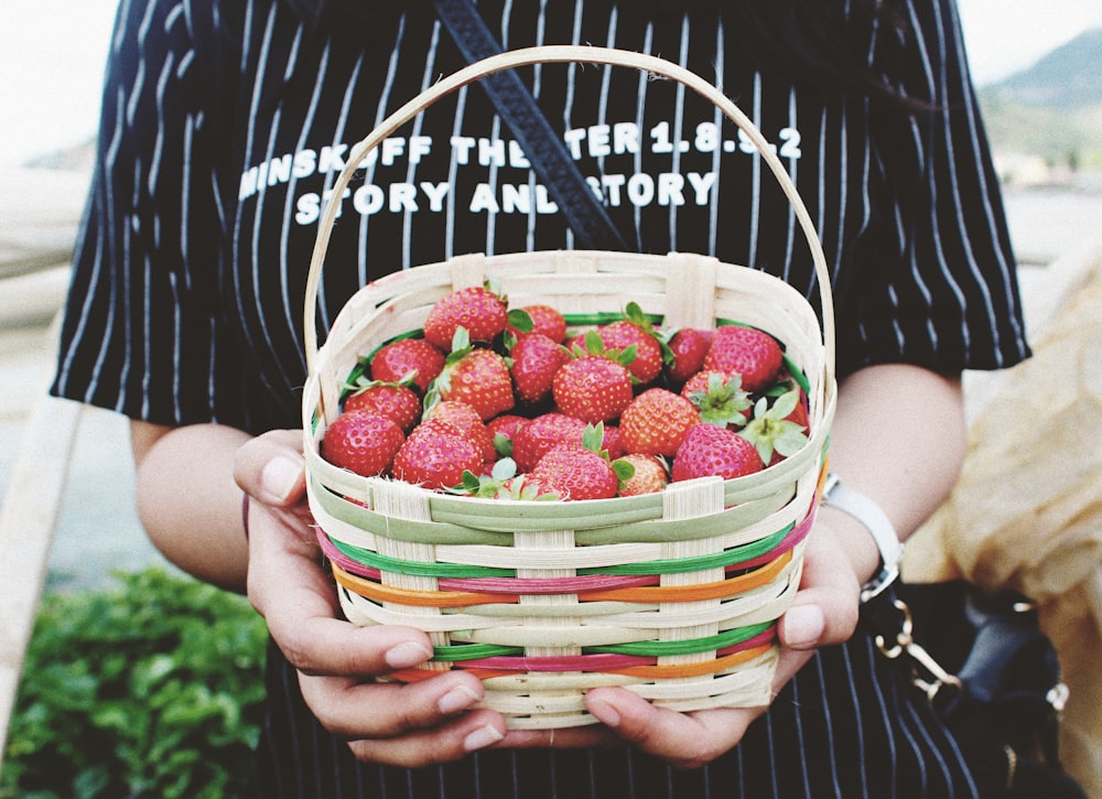 woman holding basket of strawberries