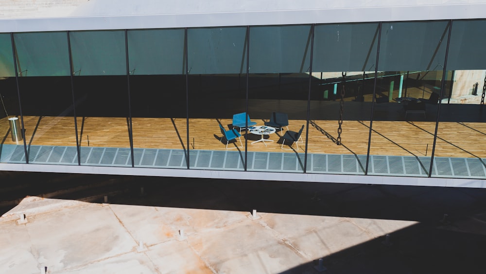 Table et chaises 5 pièces sur parquet près d’un rideau de verre