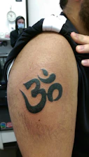 Close-up of a spiritual amulet tattoo being inked on a person's arm.
