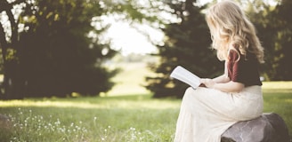 woman sitting while reading book