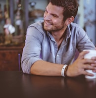 man holding cup on table