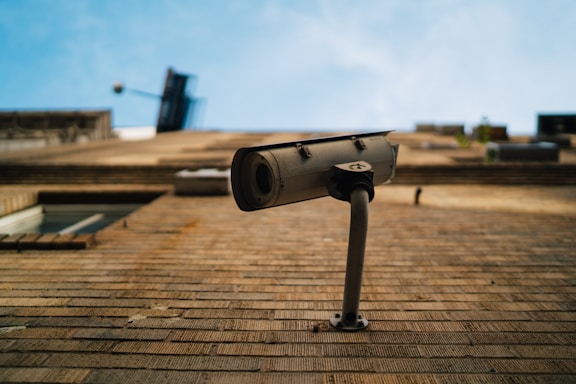 Security camera mounted on a building exterior overlooking a city street.