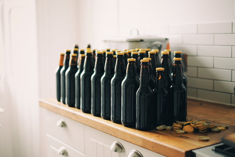 black tinted glass bottle lot on brown and white wooden cabinet