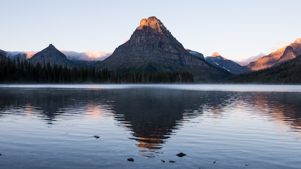 brown mountain near body of water during daytime