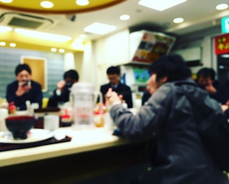 Happy customers enjoying their quick meals at a lively restaurant counter.