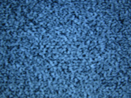 A close-up of blue static noise pattern resembling what might be seen on an old television screen without a signal. The image is uniformly filled with small light and dark blue speckles creating an abstract, textured appearance.