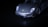 A sleek, luxury sports car is captured from a low-angle, highlighting its shining metallic body and distinctive logo on the front. The image is mostly dark, with the car emerging dramatically from the shadows.