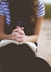 woman sitting on brown bench while reading book