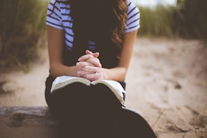 A person gently flipping through the prayer cards during a quiet moment of reflection outdoors.