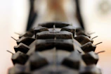 A close-up of a motorcycle tire gripping a rugged, rocky trail in the countryside.