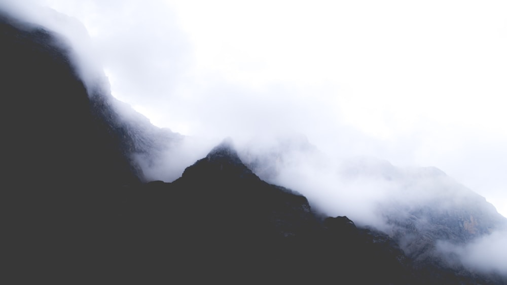 silueta de montaña cubierta de nieblas durante el día