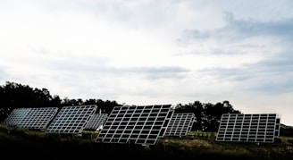 silhouette photography of assorted solar panel behind trees