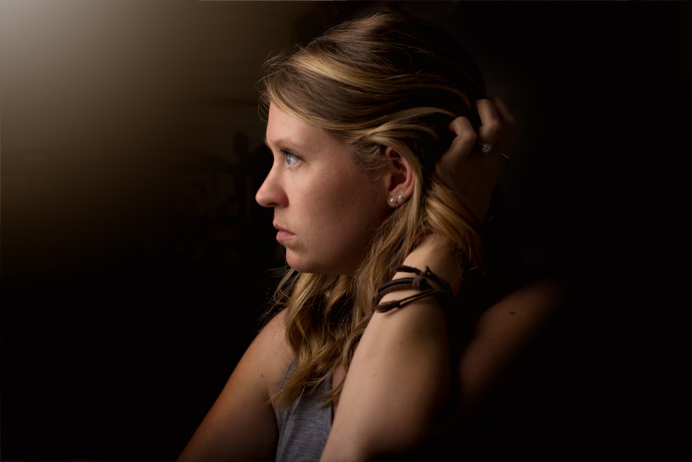 shallow focus photography of person holding her hair