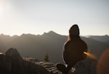 person wearing knit cap facing mountain