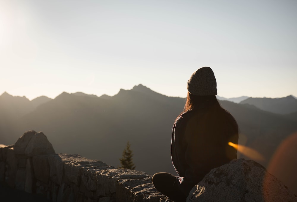 person wearing knit cap facing mountain