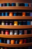 Colorful threads arranged neatly on a shelf.