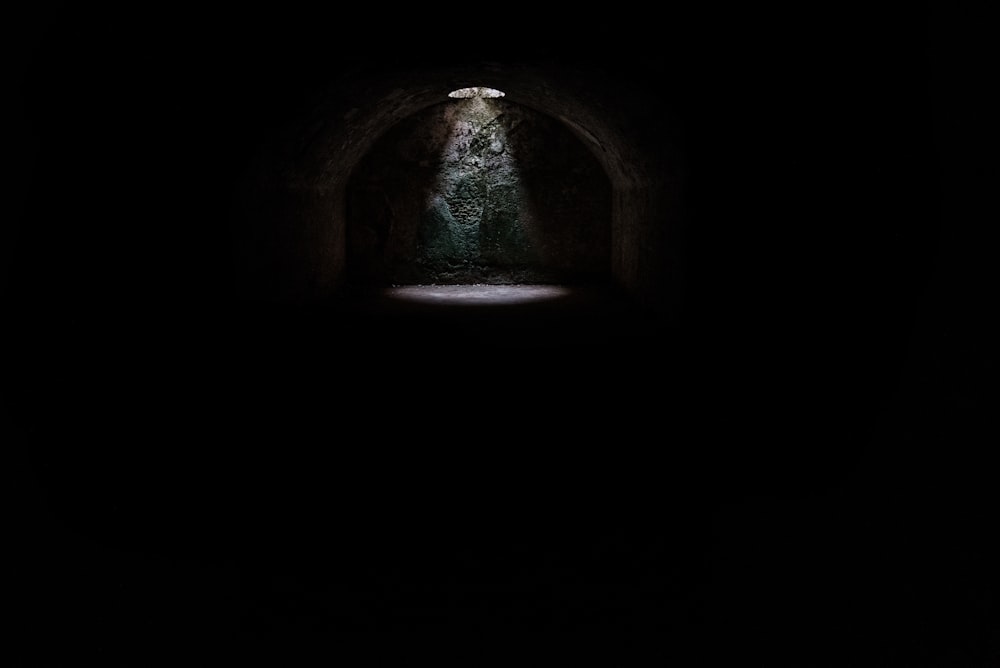 Ein Scheinwerfer aus einem Loch in einer dunklen unterirdischen Höhle auf Menorca