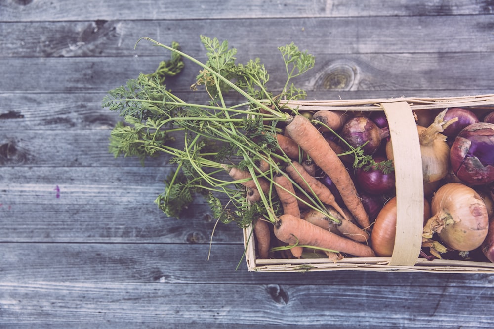 carrots and onions in brown wicker basket