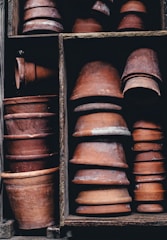 Stacks of neatly packed clay pots ready for shipment in a traditional warehouse.
