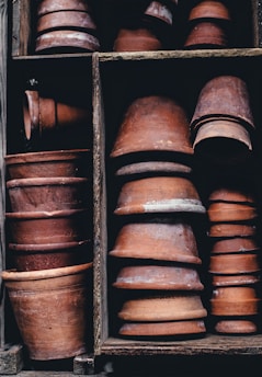 Stacks of neatly packed clay pots ready for shipment in a traditional warehouse.