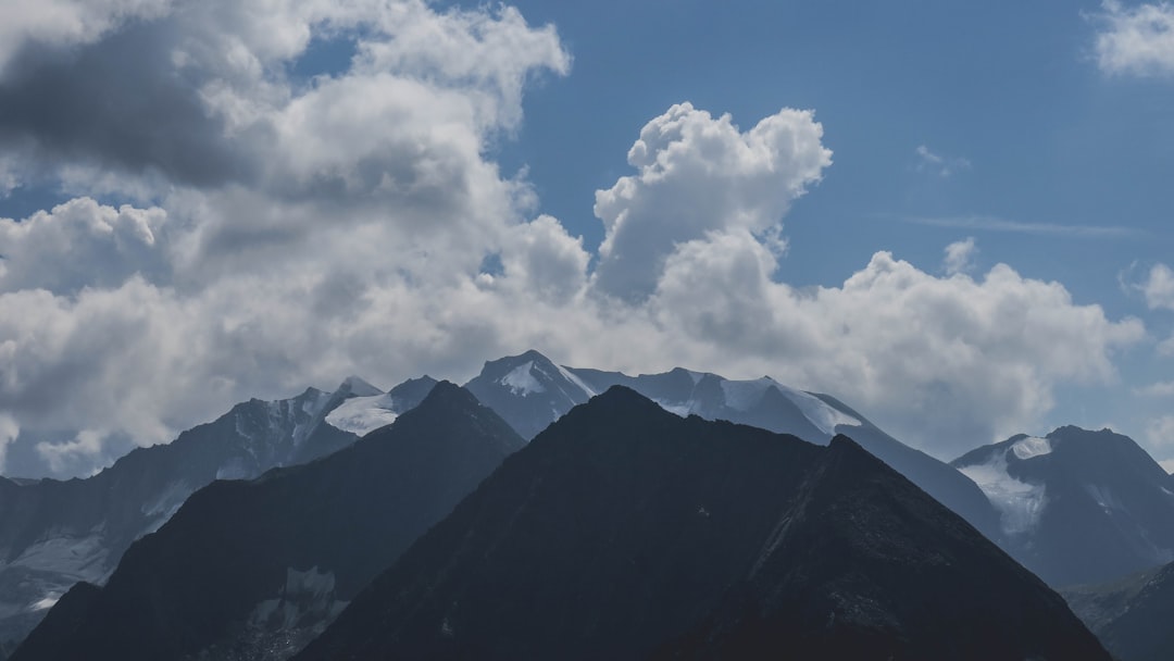 green and black mountains under white clouds and blue sky during daytime