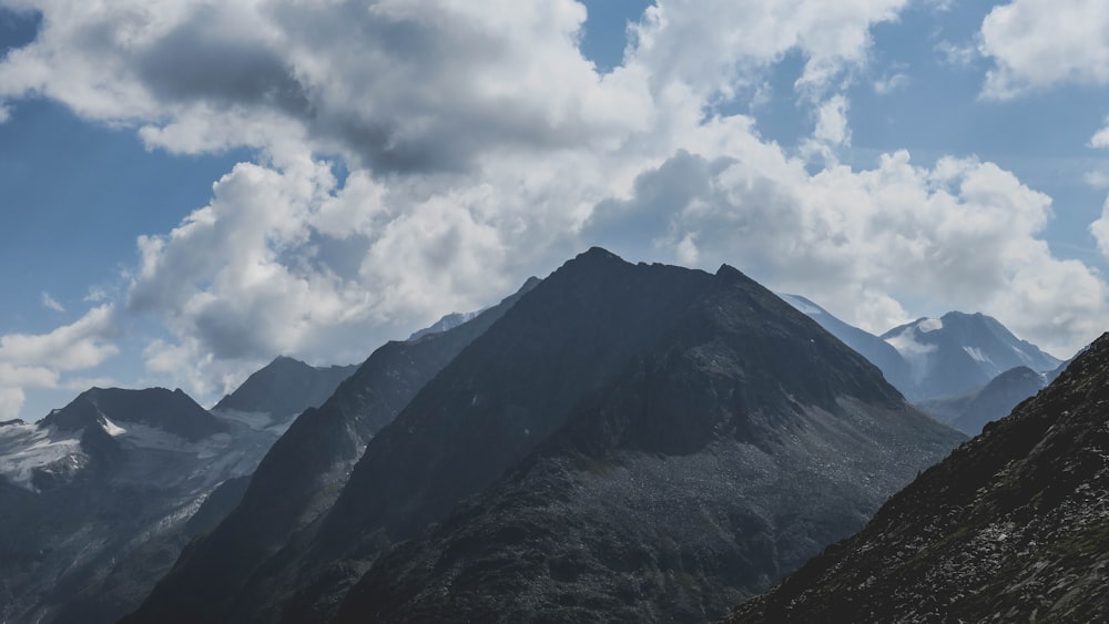 green and black mountain under white clouds and blue sky during daytime