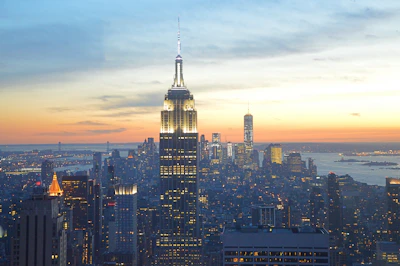 A wide-angle shot of a bustling cityscape at dusk, blending natural light with urban energy.
