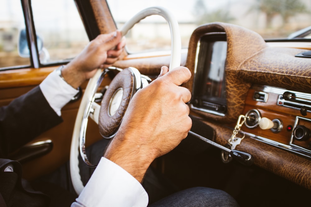 person holding vehicle steering wheel