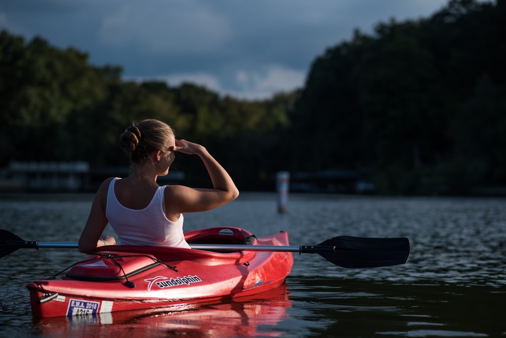 donna che guarda gli alberi mentre cavalca in kayak