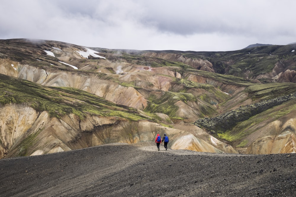 Dos personas caminando en la cima de la colina durante el día