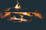 A cozy campfire glowing warmly as a family shares stories under a starry night sky.