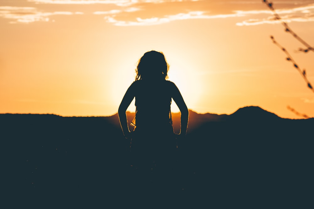 silhouette of person looking at sunset