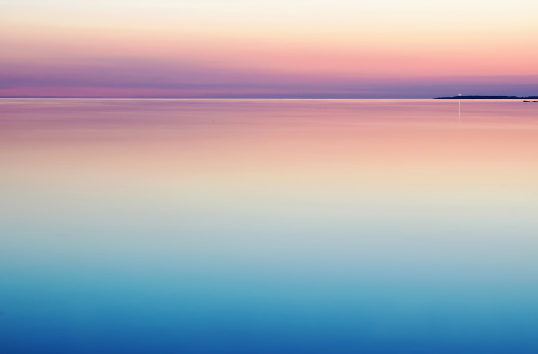 photo of blue and pink sea, calm.