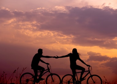 woman on bike reaching for man's hand behind her also on bike