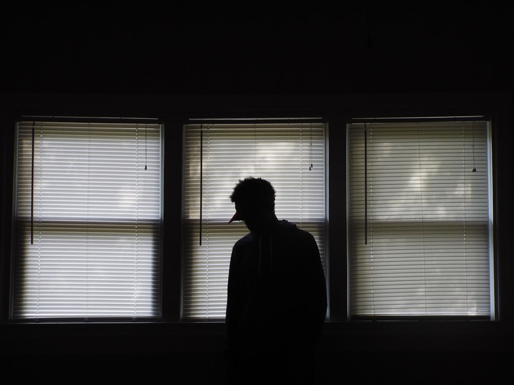 man standing infront of window blinds