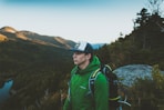 man in green jacket in forest during daytime