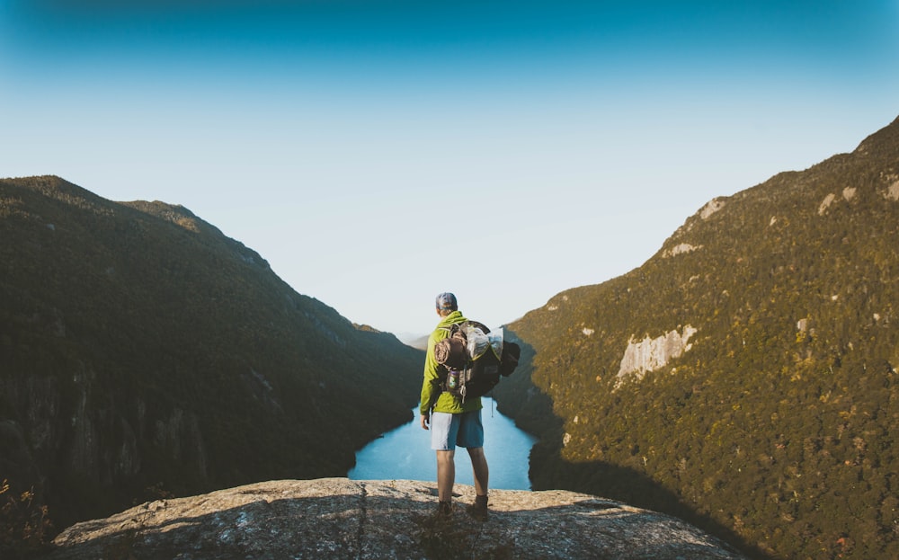 man in yellow jacket looking over river